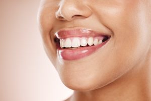 Woman displaying a bright white smile with healthy teeth and fresh lip color.