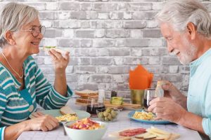 Senior couple enjoying soft foods at home after tooth extraction recovery.