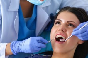Dentist examining patient's teeth during dental checkup at Ruidoso dental office.